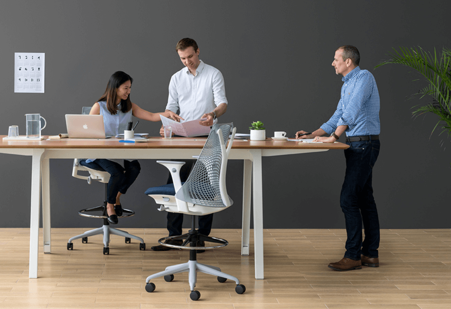 team in an office around an ergonomic chair